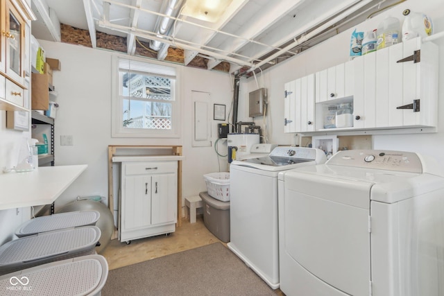 washroom featuring cabinet space, independent washer and dryer, and water heater