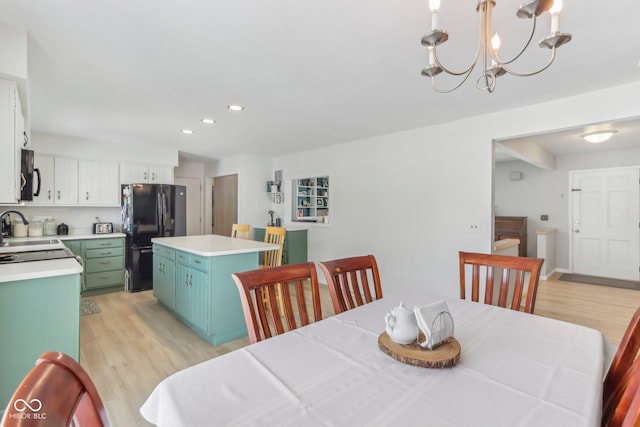 dining room with light wood finished floors, a notable chandelier, and recessed lighting