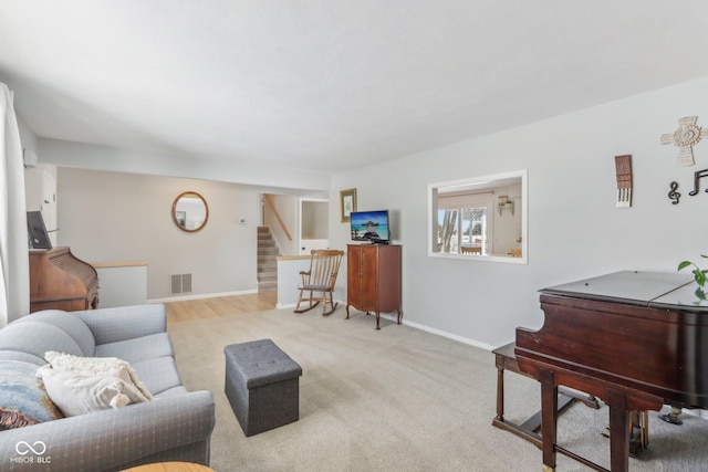 carpeted living room featuring stairway, baseboards, and visible vents