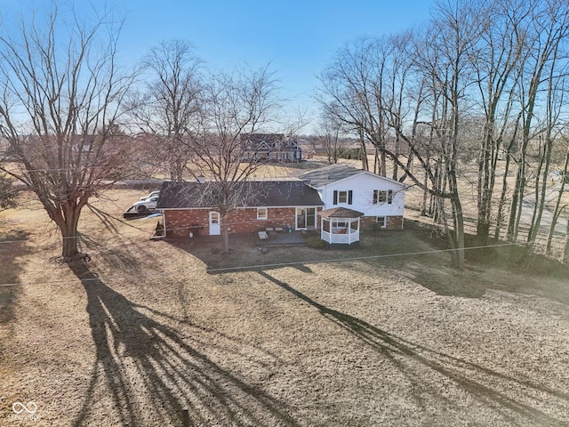 split level home featuring brick siding and dirt driveway