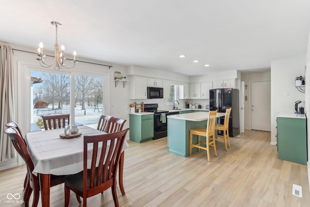 dining room featuring a chandelier, recessed lighting, baseboards, and light wood-style floors