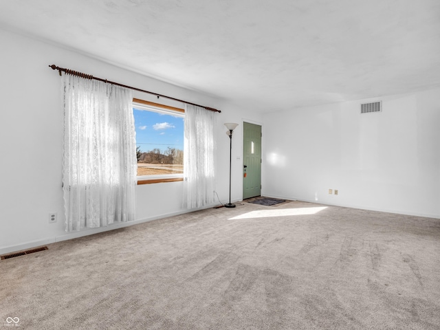 empty room featuring baseboards, visible vents, and carpet flooring