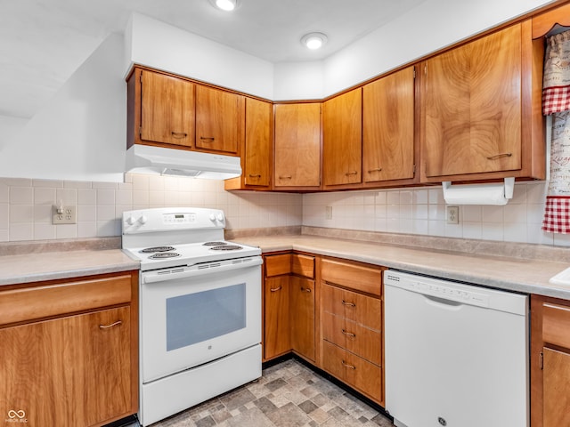 kitchen with under cabinet range hood, white appliances, light countertops, backsplash, and brown cabinetry