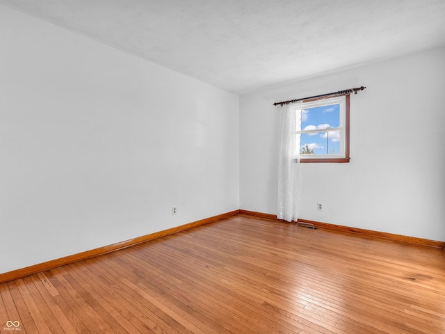 spare room with visible vents, light wood-style flooring, and baseboards