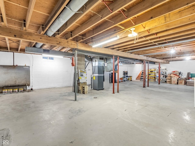 unfinished basement featuring heating unit and heating fuel