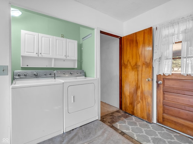 clothes washing area featuring cabinet space and separate washer and dryer