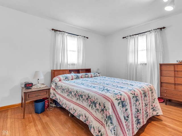 bedroom with light wood-style flooring and baseboards