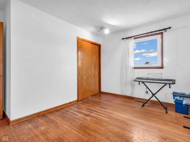 interior space featuring light wood-type flooring, a closet, and baseboards