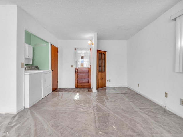 empty room featuring baseboards, washer and clothes dryer, and a textured ceiling