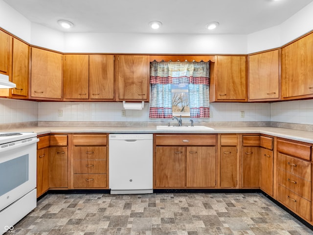 kitchen with light countertops, white appliances, a sink, and tasteful backsplash