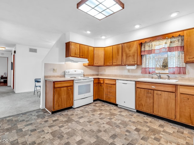 kitchen with light countertops, visible vents, a sink, white appliances, and under cabinet range hood