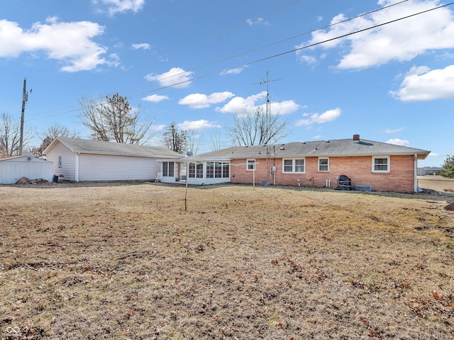 view of front of property with a sunroom, a front yard, and brick siding