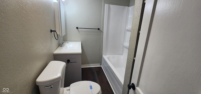 full bathroom with a textured wall, wood finished floors, vanity, and toilet