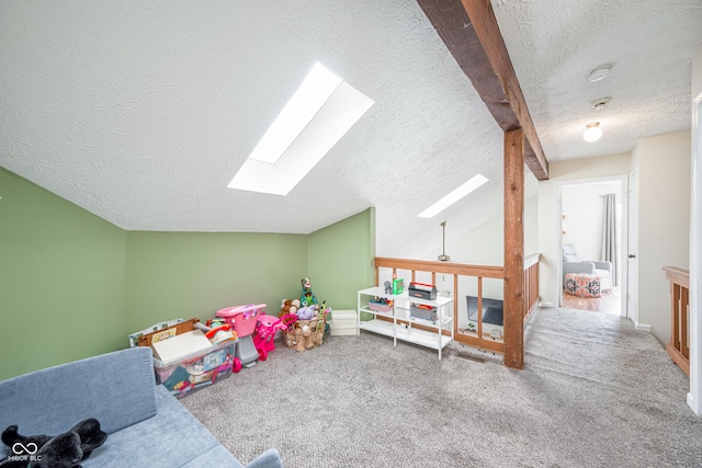 rec room with a textured ceiling, carpet floors, and lofted ceiling with skylight