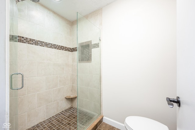 full bath with a stall shower, baseboards, toilet, and tile patterned floors