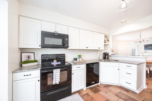 kitchen with a peninsula, black appliances, white cabinets, and a sink