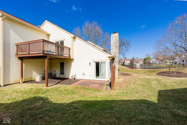 back of property featuring central AC unit, a lawn, and a chimney