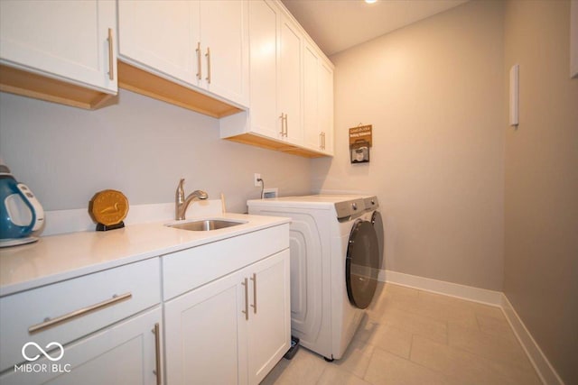 laundry area with cabinet space, light tile patterned flooring, a sink, washer and dryer, and baseboards