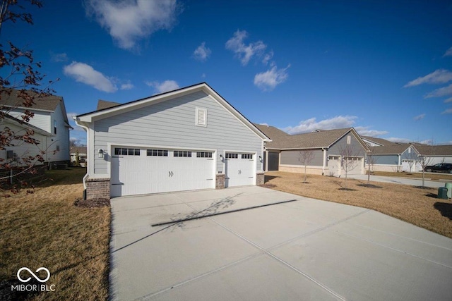 view of front of house featuring concrete driveway, an attached garage, and a front yard