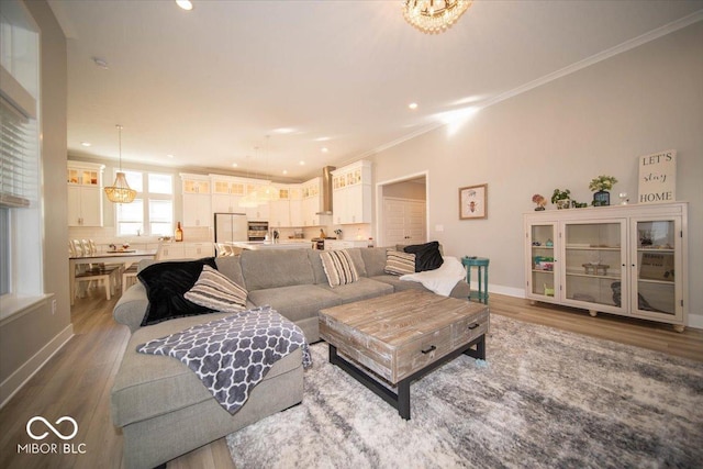 living room featuring recessed lighting, baseboards, crown molding, and wood finished floors