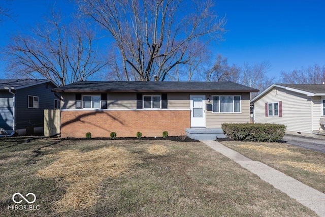 ranch-style house featuring brick siding and a front lawn