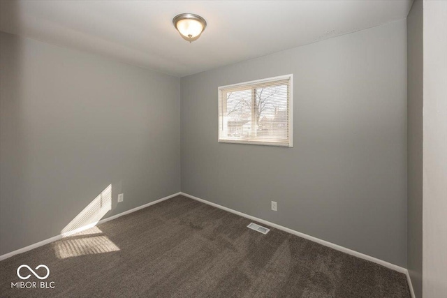 unfurnished room featuring dark colored carpet, visible vents, and baseboards