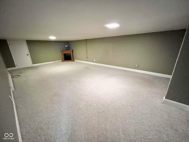 finished below grade area featuring carpet, a fireplace, and baseboards