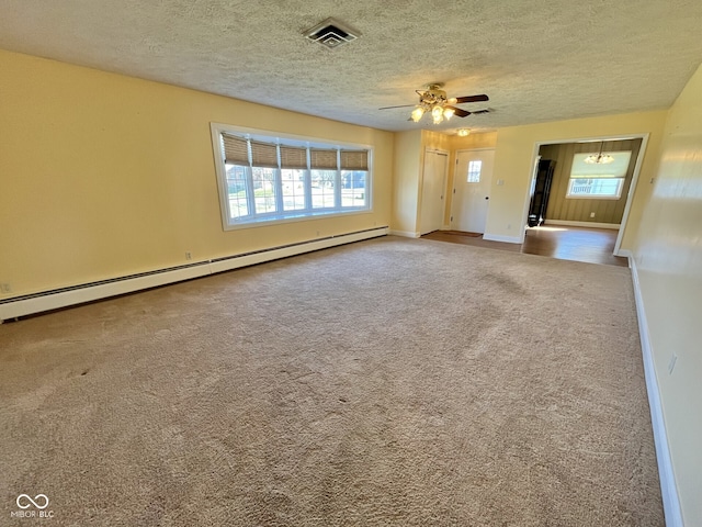 spare room featuring a textured ceiling, a baseboard radiator, carpet floors, visible vents, and baseboards