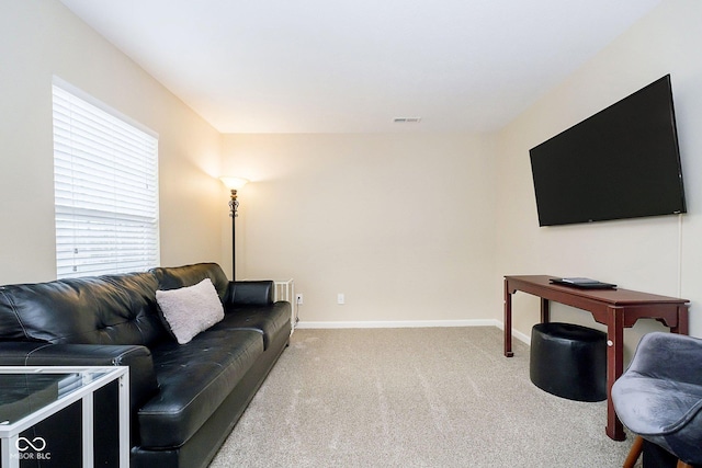 carpeted living area featuring visible vents and baseboards