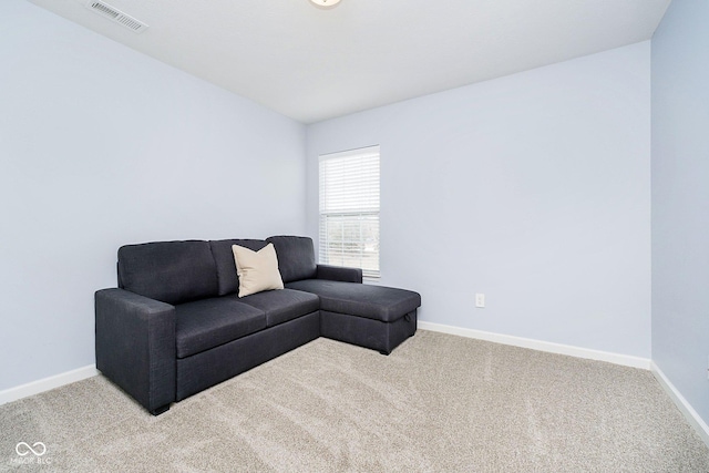 living area featuring carpet floors, visible vents, and baseboards