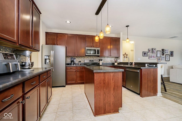 kitchen featuring visible vents, appliances with stainless steel finishes, backsplash, a center island, and dark countertops