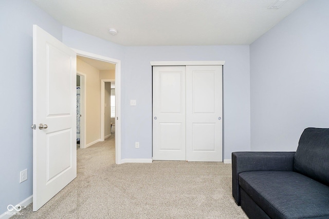 living area featuring light carpet and baseboards