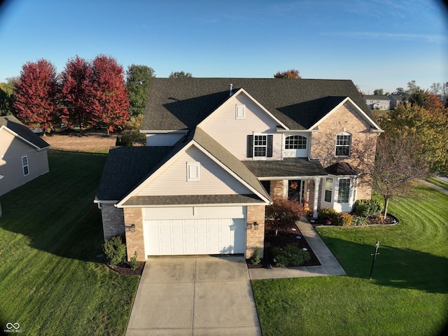 traditional-style house with an attached garage, brick siding, driveway, and a front lawn