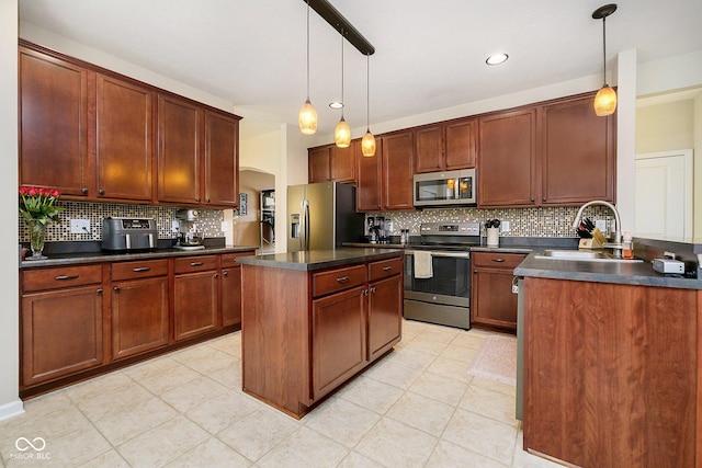 kitchen featuring arched walkways, tasteful backsplash, dark countertops, appliances with stainless steel finishes, and a sink