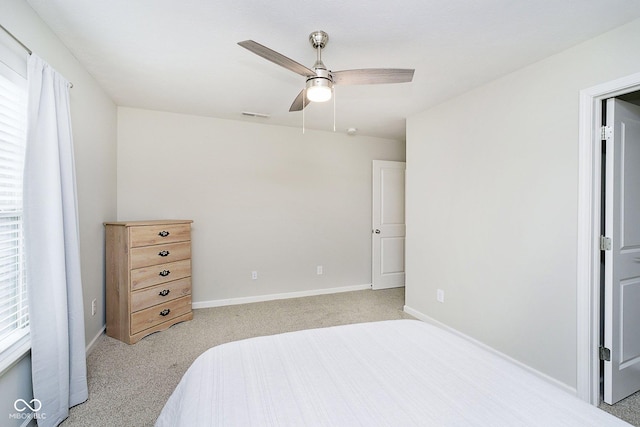 bedroom featuring baseboards, ceiling fan, visible vents, and light colored carpet