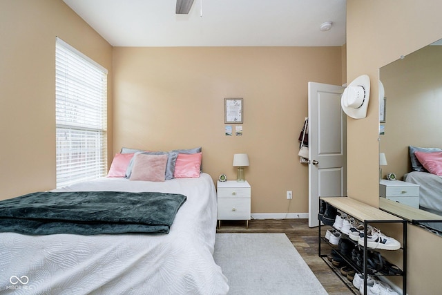 bedroom with ceiling fan, baseboards, and wood finished floors