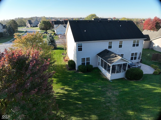 back of house featuring a sunroom and a yard