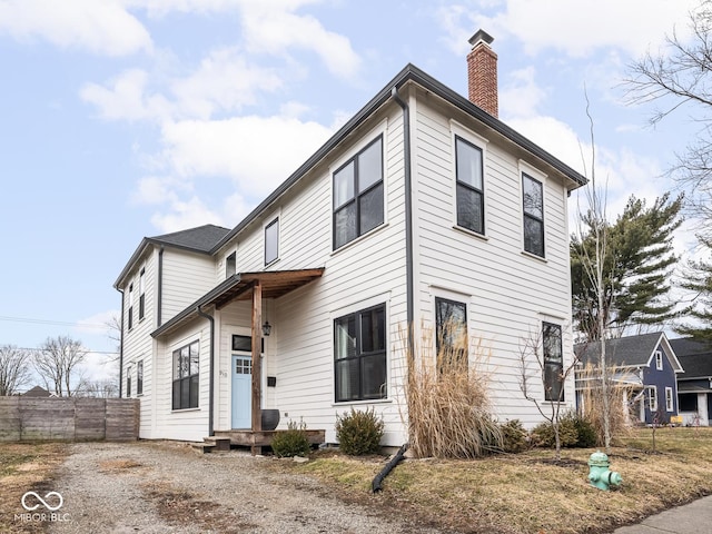 view of front of property featuring a chimney and fence