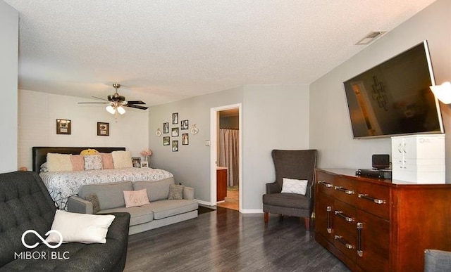 bedroom with a ceiling fan, baseboards, visible vents, dark wood-type flooring, and a textured ceiling