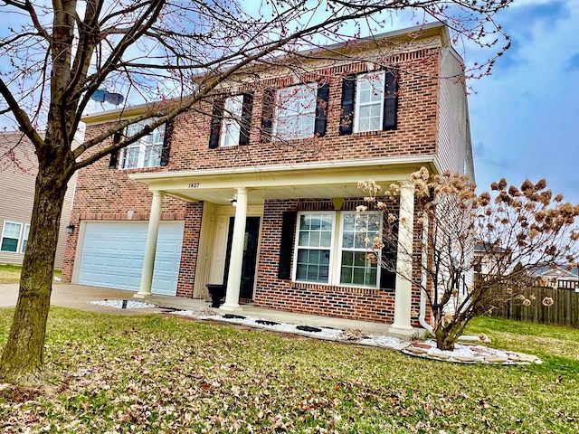 traditional-style home featuring brick siding, a front lawn, fence, a garage, and driveway