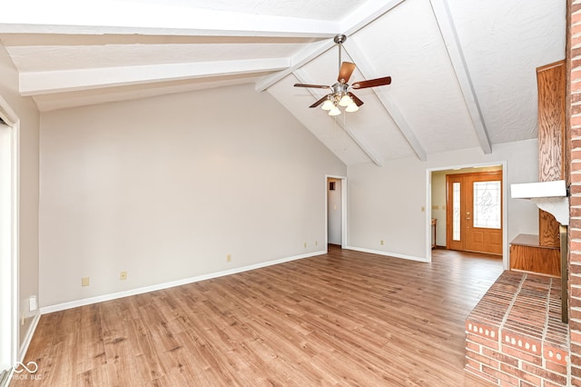 unfurnished living room featuring ceiling fan, beam ceiling, light wood-style flooring, and baseboards