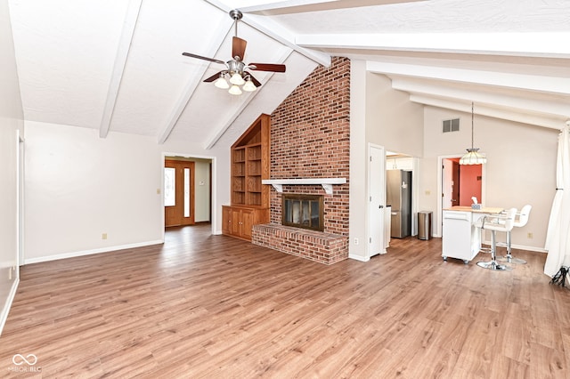 unfurnished living room featuring light wood finished floors, a brick fireplace, beam ceiling, and visible vents