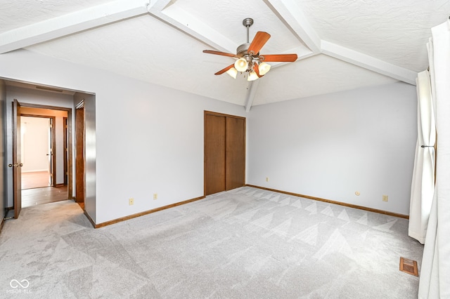 unfurnished bedroom with light colored carpet, visible vents, vaulted ceiling with beams, and baseboards