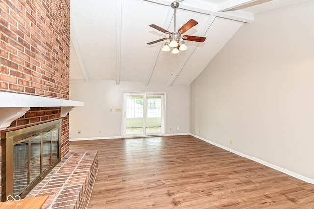 unfurnished living room featuring light wood-type flooring, a fireplace, baseboards, and beamed ceiling