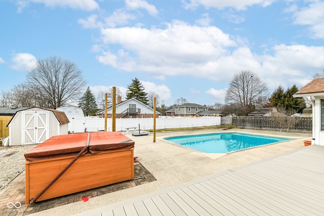 view of swimming pool featuring a fenced in pool, a hot tub, a patio area, a shed, and a fenced backyard