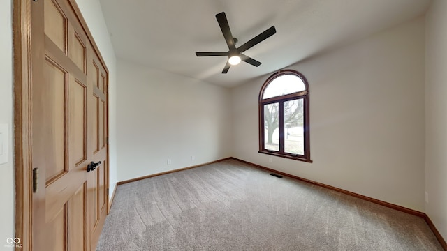 spare room featuring light carpet, baseboards, visible vents, and a ceiling fan