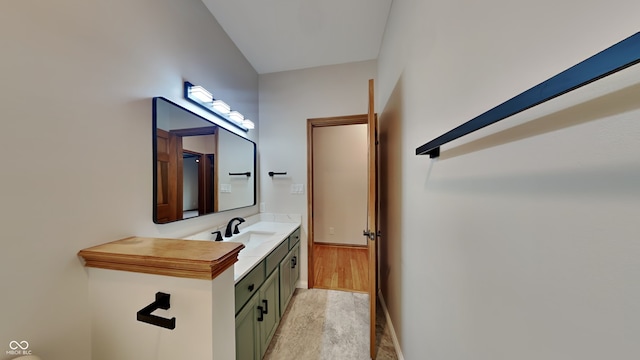 bathroom featuring baseboards, wood finished floors, and vanity