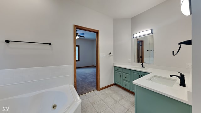 bathroom with a jetted tub, double vanity, a sink, and tile patterned floors