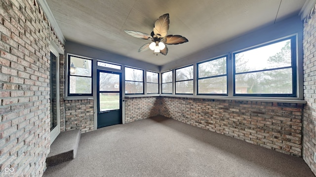 unfurnished sunroom featuring ceiling fan