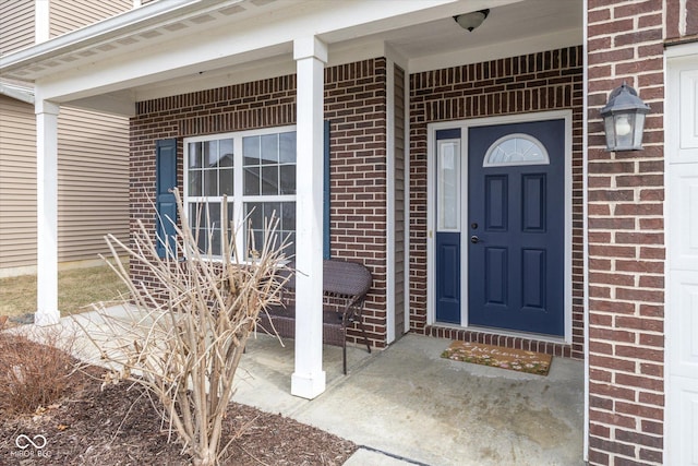 doorway to property featuring brick siding